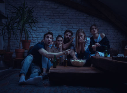 Group of friend watching scary movie at home